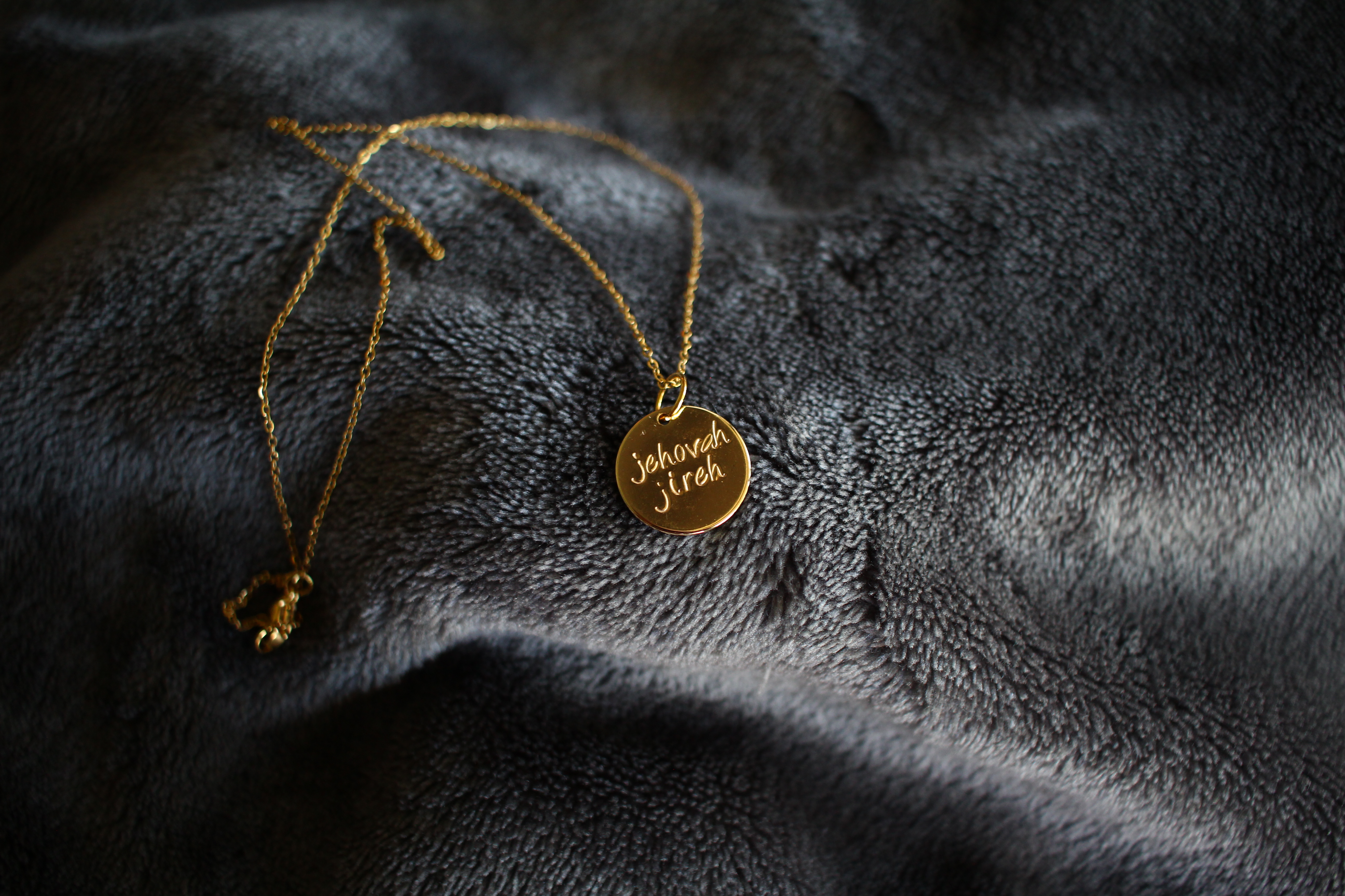 Gold necklace with 'Jehovah Jireh' written on it